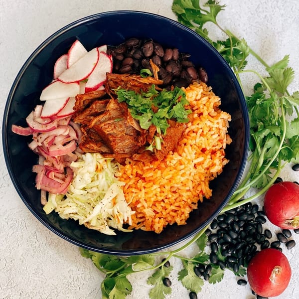 A vibrant Sullivan Taqueria Mexican bowl with rice, beans, pork, radishes, and pickled onions.